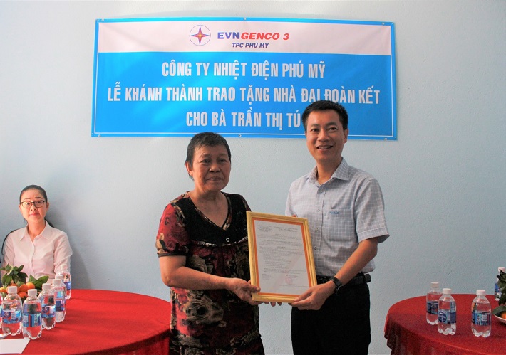 Ông Nguyễn Xuân Hiệp - Phó giám đốc, Chủ tịch Công đoàn Công ty Nhiệt điện Phú Mỹ trao nhà cho bà Trần Thị Tú