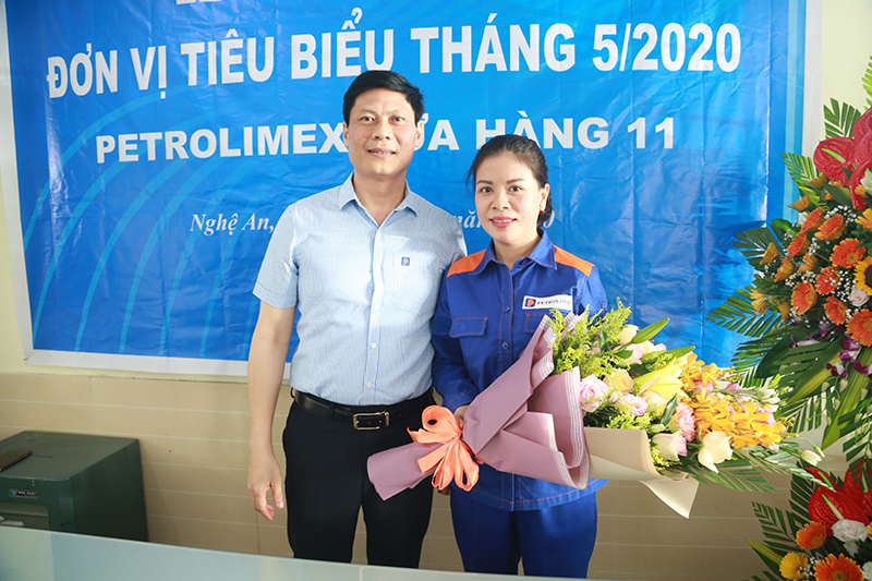 Phó giám đốc Võ Anh Tuấn trao hoa và phần thưởng đến nhân viên bán hàng Nguyễn Thị Ý khi nhặt được của rơi trả người đánh mất.