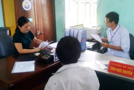 Công chức tư pháp - hộ tịch xã Đường Hoa, huyện Hải Hà, tỉnh Quảng Ninh đang tiếp nhận giấy tờ, hồ sơ của công dân tại bộ phận “Một cửa”.