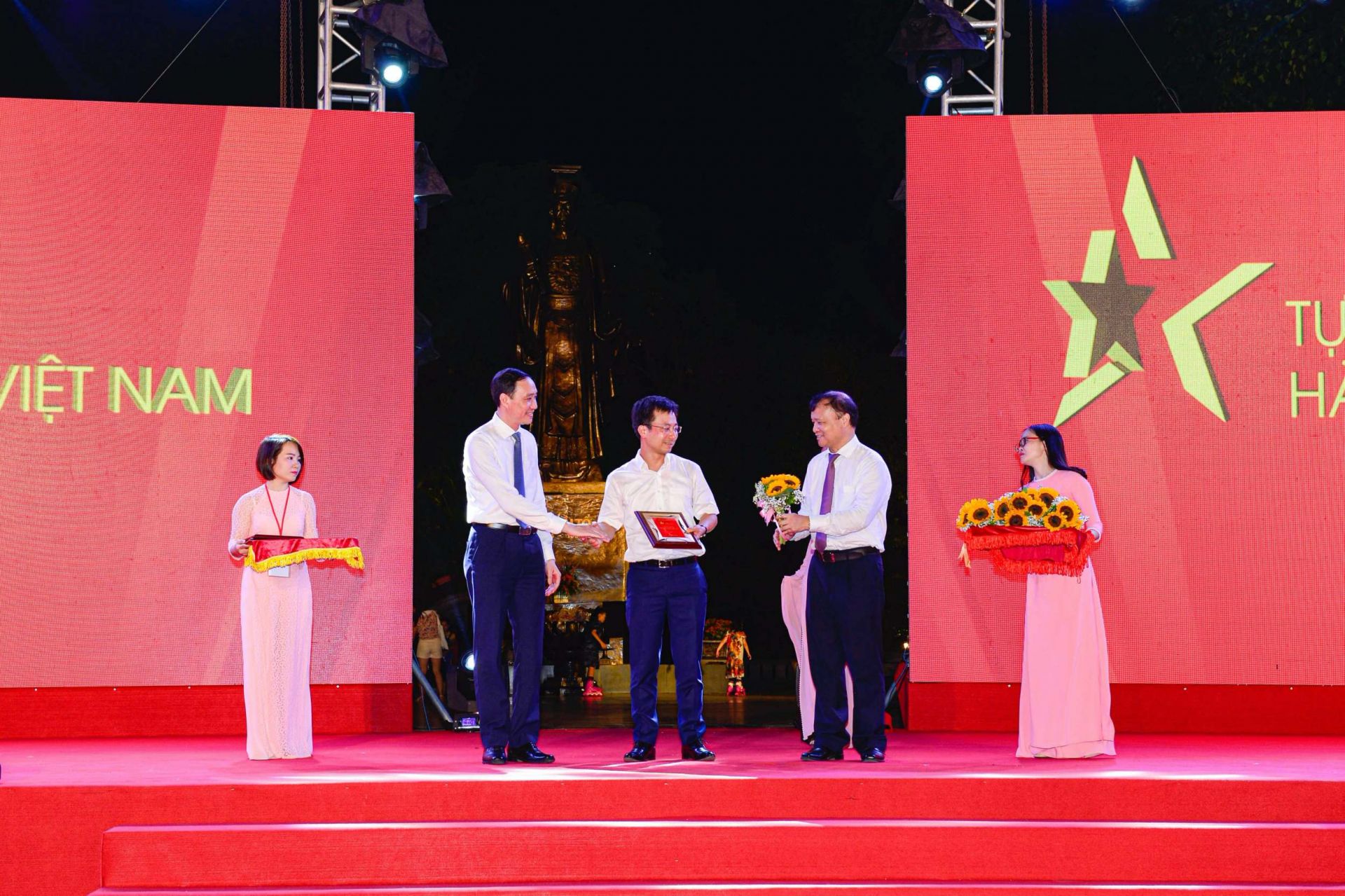 Phó Chủ tịch Ủy ban Trung ương Mặt trận Tổ quốc Việt Nam Phùng Khánh Tài (trái) và Thứ trưởng Bộ Công Thương Đỗ Thắng Hải (phải) trao kỷ niệm chương cho đại diện Vụ Thị trường trong nước, Bộ Công Thương