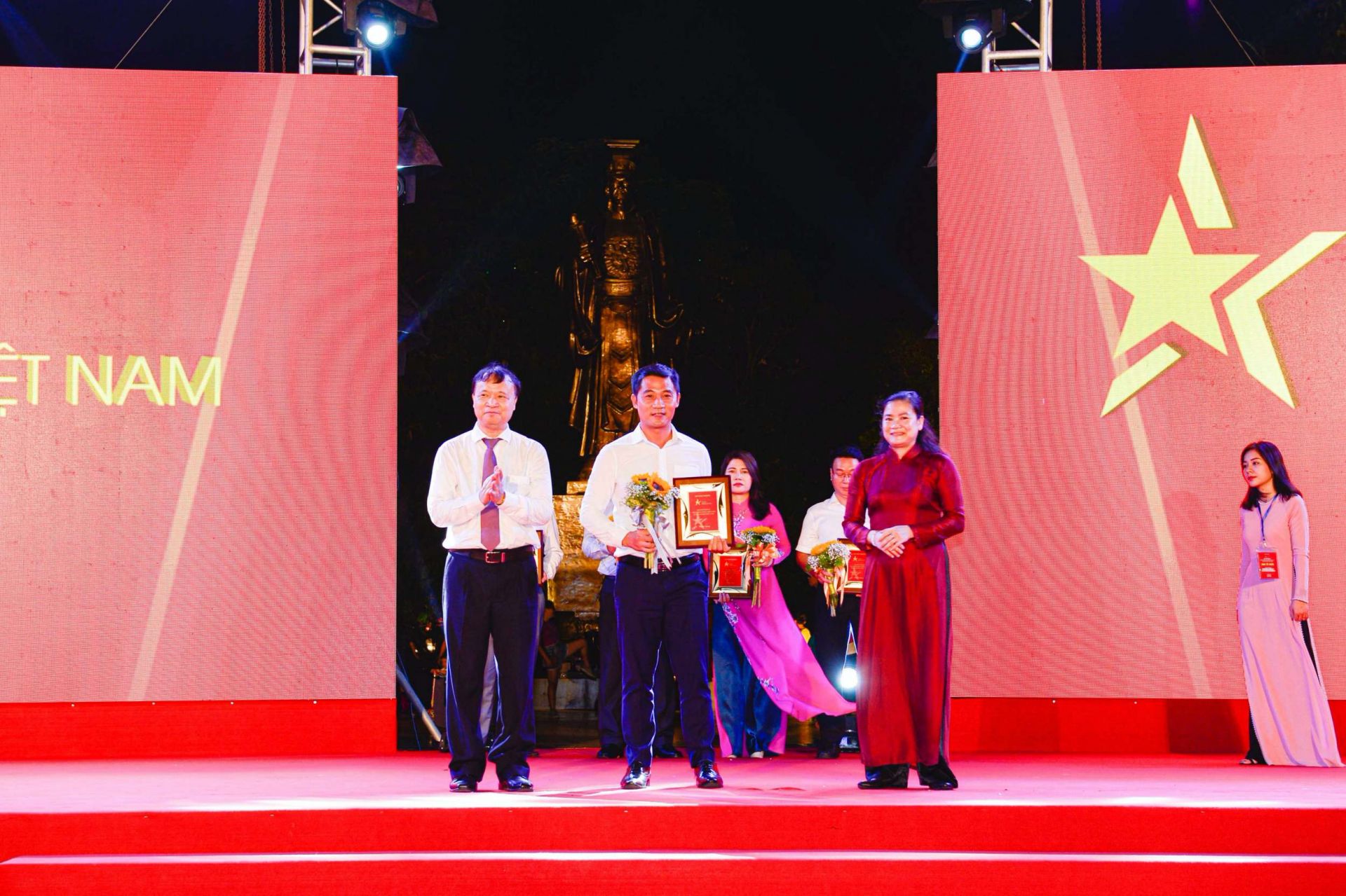 Thứ trưởng Bộ Công Thương Đỗ Thắng Hải (trái) và Phó Chủ tịch Hội Liên hiệp Phụ nữ Việt Nam Đỗ Thị Thu Thảo (phải) trao kỷ niệm chương cho đại diện Tổng Công ty May Việt Tiến - CTCP