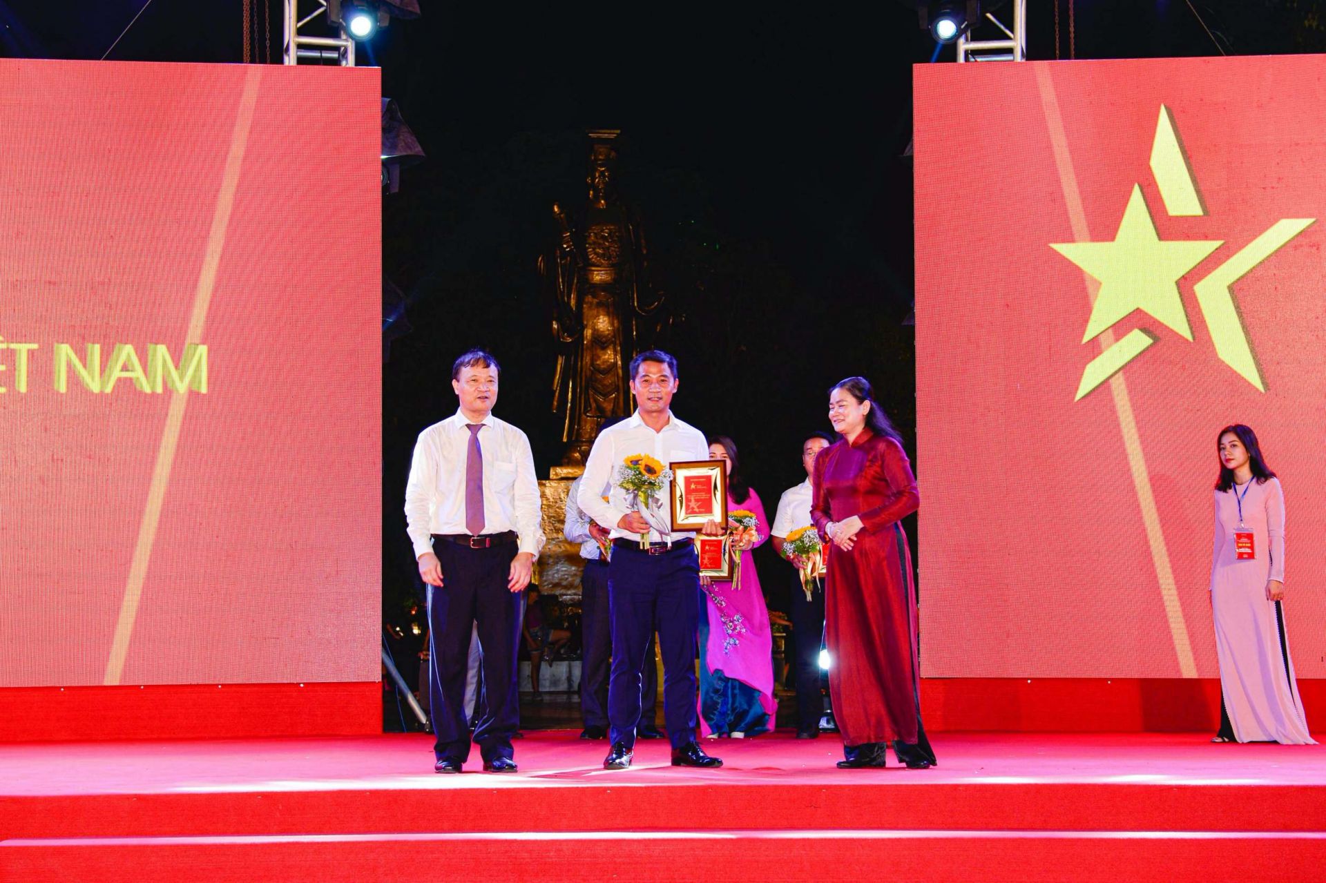 Thứ trưởng Bộ Công Thương Đỗ Thắng Hải (trái) và Phó Chủ tịch Hội Liên hiệp Phụ nữ Việt Nam Đỗ Thị Thu Thảo (phải) trao kỷ niệm chương cho đại diện Tổng Công ty May Việt Tiến - CTCP