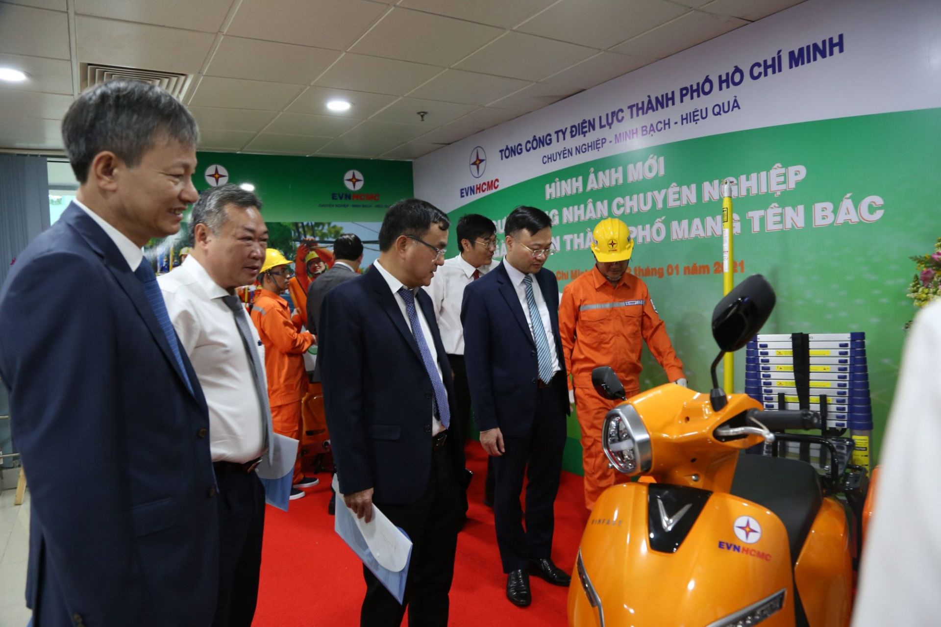 Ông Phạm Quốc Bảo (áo trắng) - Bí thư Đảng ủy, Chủ tịch HĐTV EVNHCMC giới thiệu với lãnh đạo EVN về mẫu xe và bộ công cụ mới cho người công nhân điện lực Thành phố