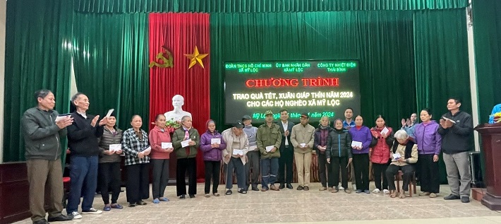 Đồng chí Nguyễn Việt Hùng - Chủ tịch Công đoàn Công ty (đứng giữa) trao quà cho các hộ gia đình chính sách tại Xã Mỹ Lộc