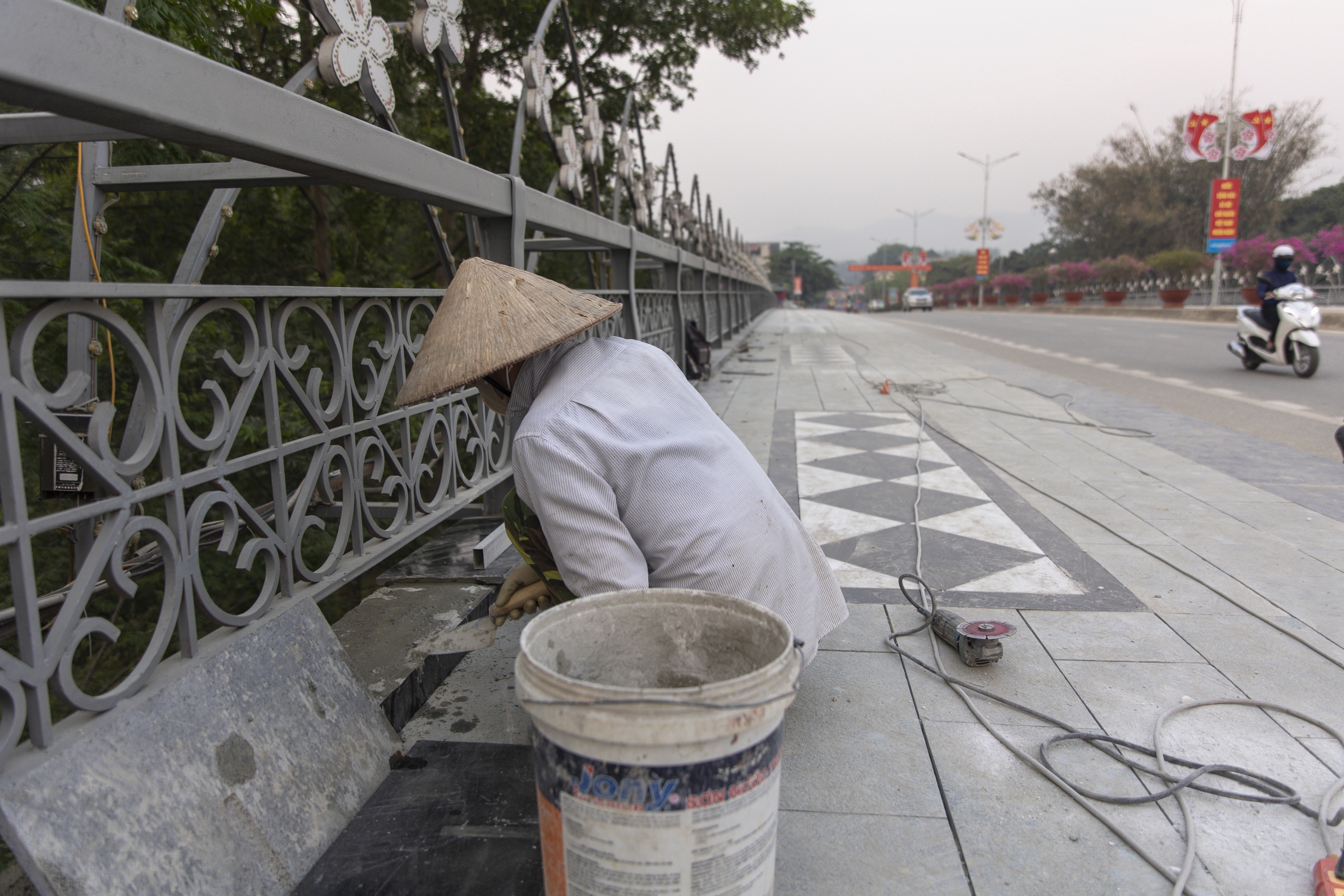 Anh Lò Văn Kiên, nhân viên ốp lát vỉa hè, đang hoàn thiện những hạng mục cuối ốp lát, trang trí lại vỉa hè cầu A1 trước khi bàn giao. Ngoài công trình này, trên địa bàn thành phố cũng có rất nhiều tuyến phố khác được sửa sang, nâng cấp dịp kỷ niệm 70 năm chiến thắng Điện Biên Phủ.