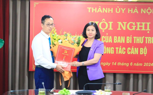 Die ständige stellvertretende Sekretärin des Parteikomitees von Hanoi, Nguyen Thi Tuyen, stellte die Entscheidung des Zentralen Parteisekretariats vor und überreichte Herrn Hoang Van Toai Blumen, um ihm zu gratulieren. Foto von : Quang Thai