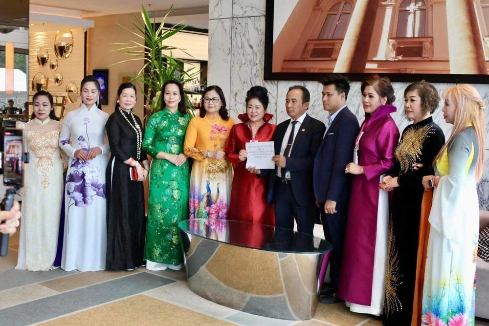 Ms. Trinh Thi Mui (sixth from left), Vice President of the Vietnamese Women's Forum in Europe, presented 7,500 euros to Mr. Tran Anh Tuan, President of the Vietnamese Association in Poland, witnessed by Mr. Nguyen Duc Quang (fourth from right), Counselor and Deputy Ambassador of Vietnam to Poland. (Photo: Phuong Hoa/Vietnam+)
