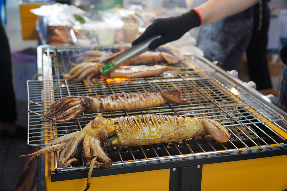 Hier können Besucher Hunderte einzigartiger Spezialitäten aus Khanh Hoa und einigen anderen Regionen genießen. Auf dem Foto ist das gegrillte Tintenfischgericht ansprechend und aromatisch.