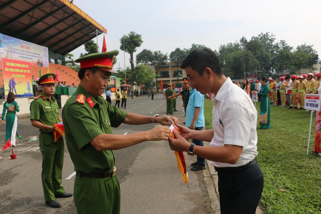 Đại tá Huỳnh Ngọc Quan - Phó Trưởng Phòng PC07 - Công an TP Hồ Chí Minh trao cờ lưu niệm cho các đội cơ sở tham gia Hội thi PCCC&CNCH