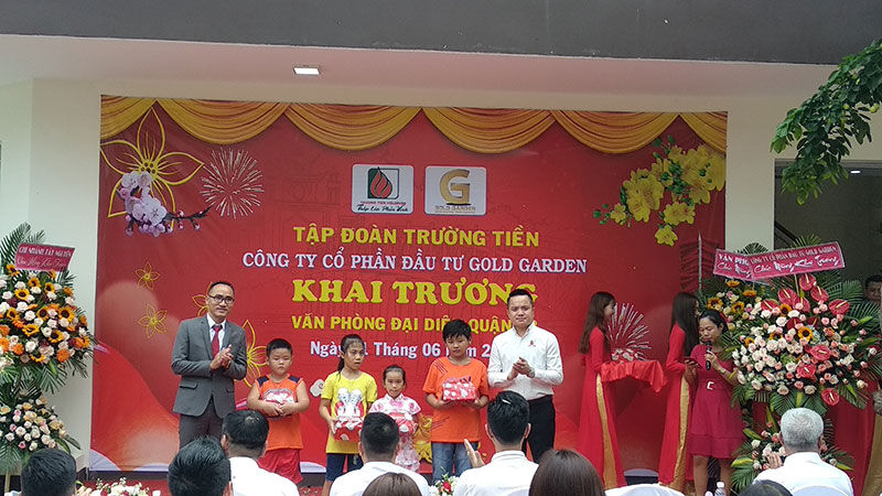 Ông Khiếu Xuân Khương, Tổng Giám đốc Tập đoàn Trường Tiền(áo trắng) và ông Phạm Duy - Trưởng phòng Đại diện quận 12 trao những phần quà cho các học sinh nghèo hiếu học trên địa bàn.