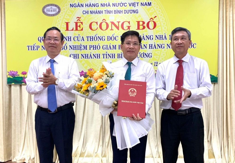 Ông Nguyễn Văn Dành và ông Võ Đình Phong, Giám đốc NHNN chi nhánh Bình Dương trao quyết định bổ nhiệm cho ông Phan Trọng Nghĩa