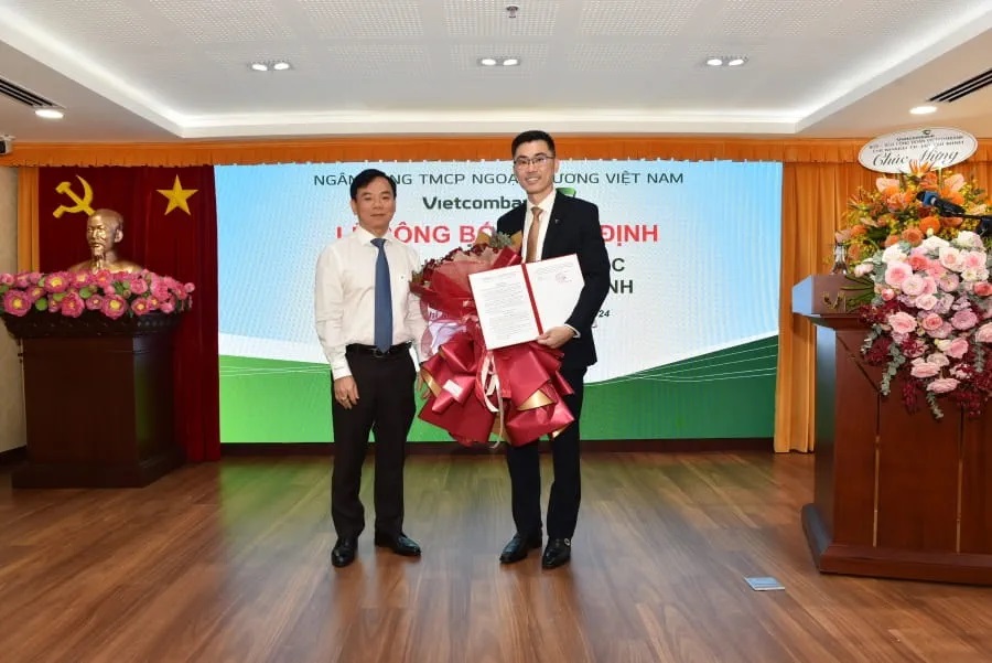 Ông Đặng Hoài Đức - Phó Tổng Giám đốc Vietcombank (bên trái) trao quyết định bổ nhiệm và hoa chúc mừng ông Trần Viết Quang Khoa - tân Phó giám đốc Chi nhánh TP. Hồ Chí Minh