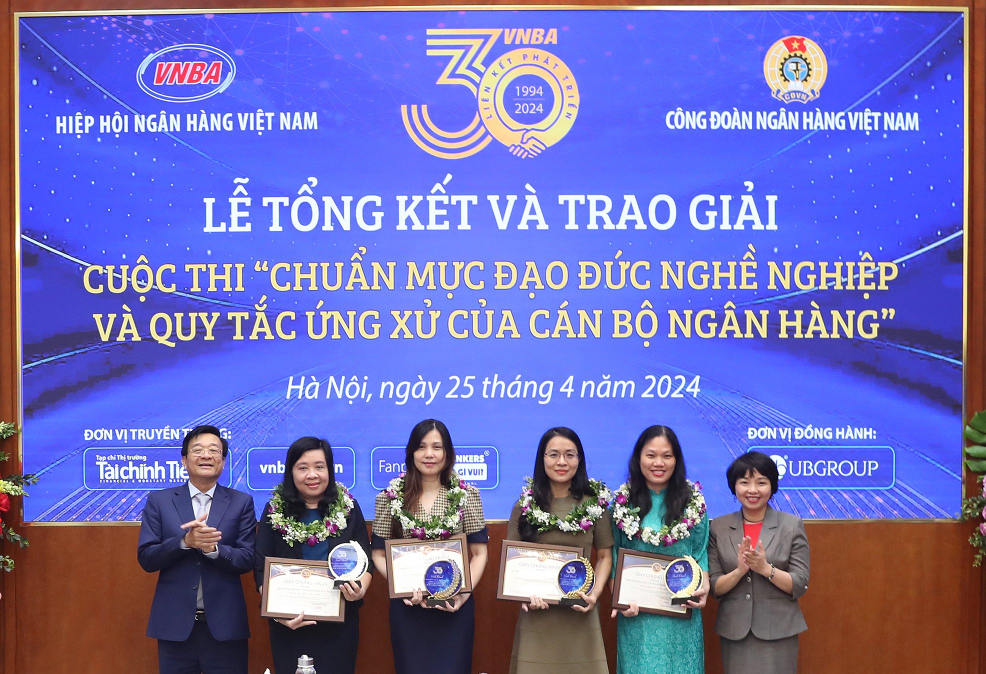 Ông Nguyễn Quốc Hùng và bà Lê Thị Mai Hương trao hoa, cúp, giấy chứng nhận cho 4 đơn vị, vụ, cục, chi nhánh NHNN tỉnh, thành phố tích cực nhất